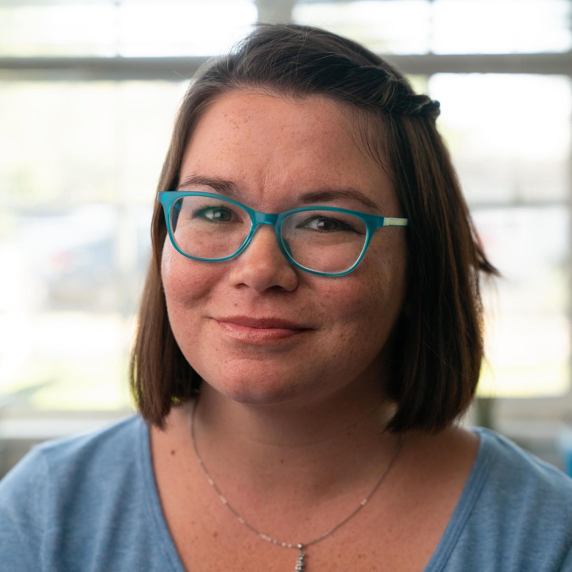 A close up photo of Sarah, a woman diagnosed with MS, smiling.