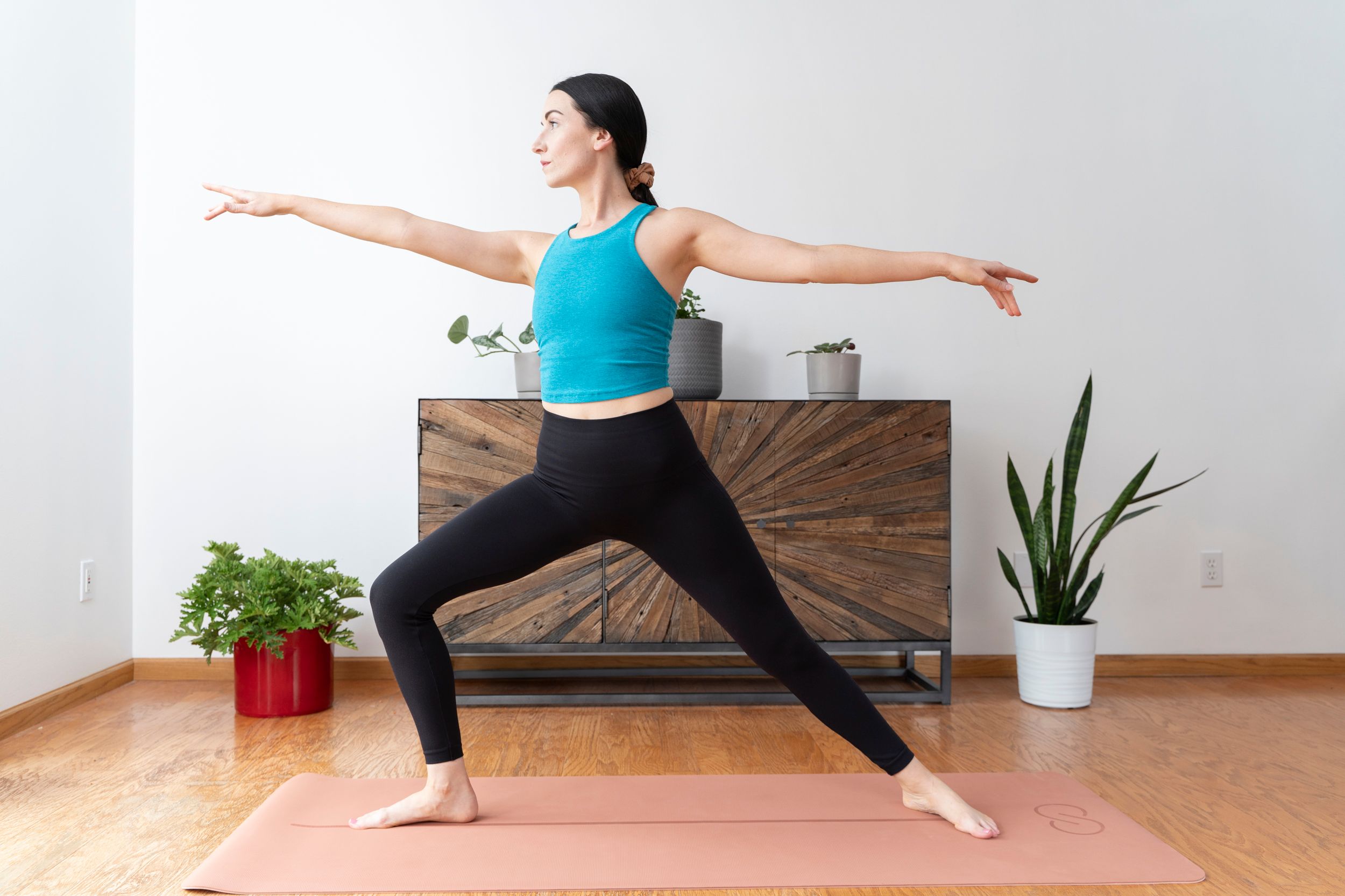 Gina, a woman with MS, doing yoga on a yoga mat as part of her integrative therapy. 