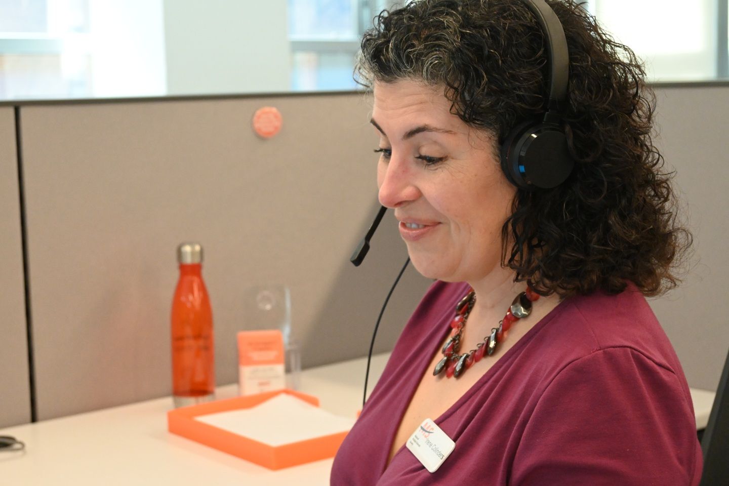 An MS Navigator speaking on a call to someone with questions about MS through a headset.