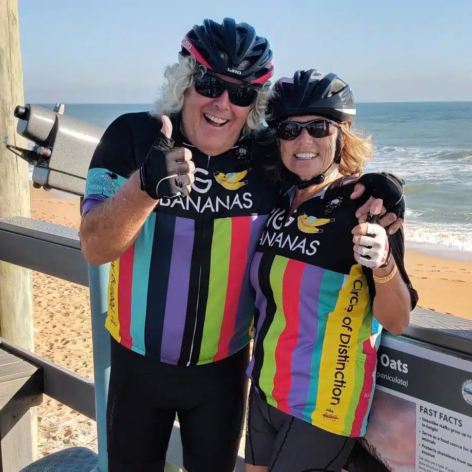 Bruce and his wife, Linda in cycling apparel standing on a pier at the beach after a Bike MS event.