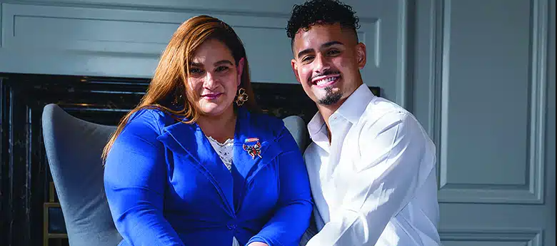 Bryan sitting next to his mother, Luz, as both smile.